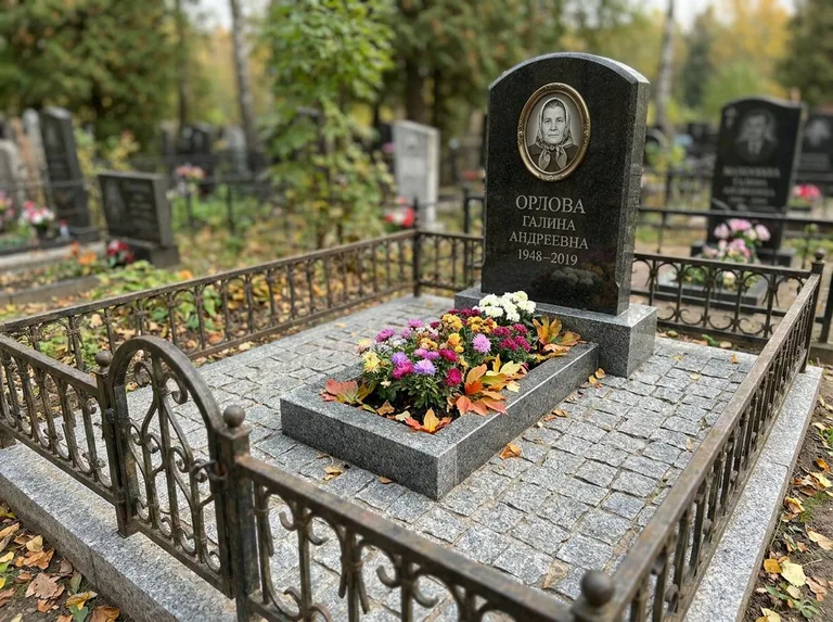 Благоустроенное захоронение с гранитной плиткой, оградой и цветником в Кемерово