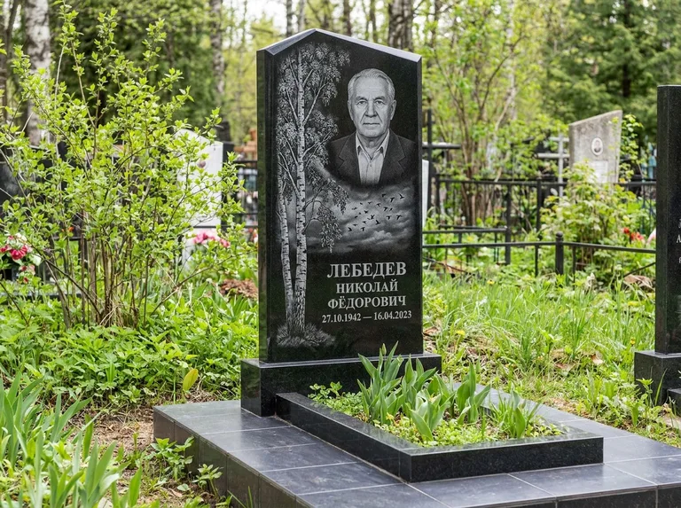Памятник с гравировкой берёзы: вертикальная стела со скошенным верхом — берёза и стая птиц в небе, гранитный цоколь с тёмной плиткой, работа «Лебедев» в Кемерово