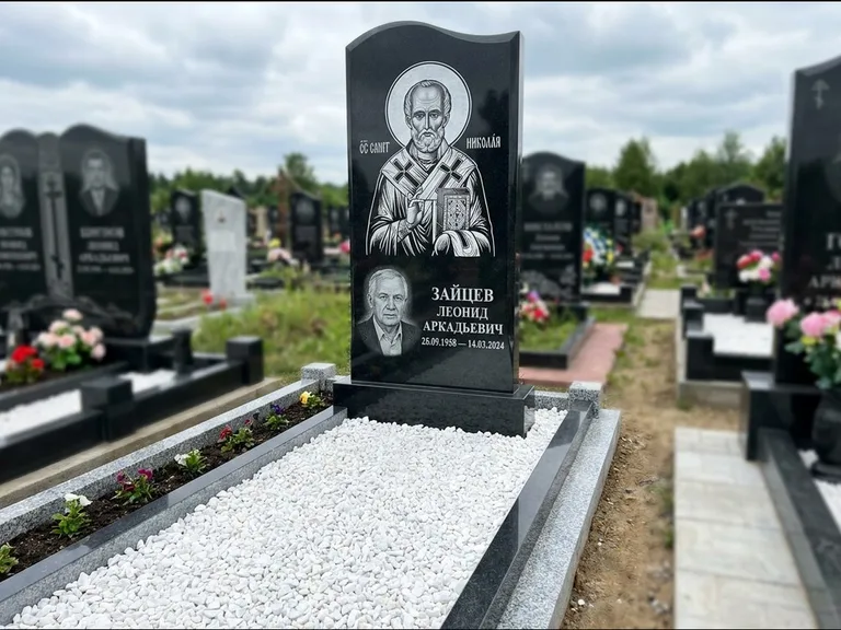 Памятник с гравировкой иконы: стела с крестообразным навершием — икона в резной рамке-киоте, газон без ограды, стриженая трава, работа «Раевская» в Кемерово