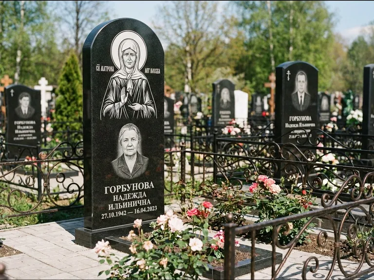Памятник с гравировкой иконы: стела с арочным верхом и киотом под образ — гравировка образа Матроны Московской, гранитный цоколь с тёмной плиткой, работа «Ковалёв» в Кемерово