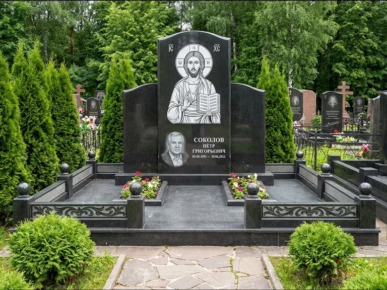 Памятник с гравировкой иконы: широкая горизонтальная лежачая плита-стела — икона в резной рамке-киоте, серая гравийная отсыпка с бордюром, работа «Богданова» в Кемерово