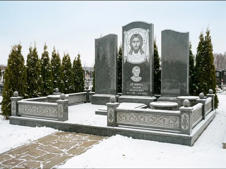 Памятник с гравировкой иконы: узкая вертикальная стела-пилон с ликом — икона в резной рамке-киоте, открытая лужайка без ограды, работа «Одинцов» в Кемерово