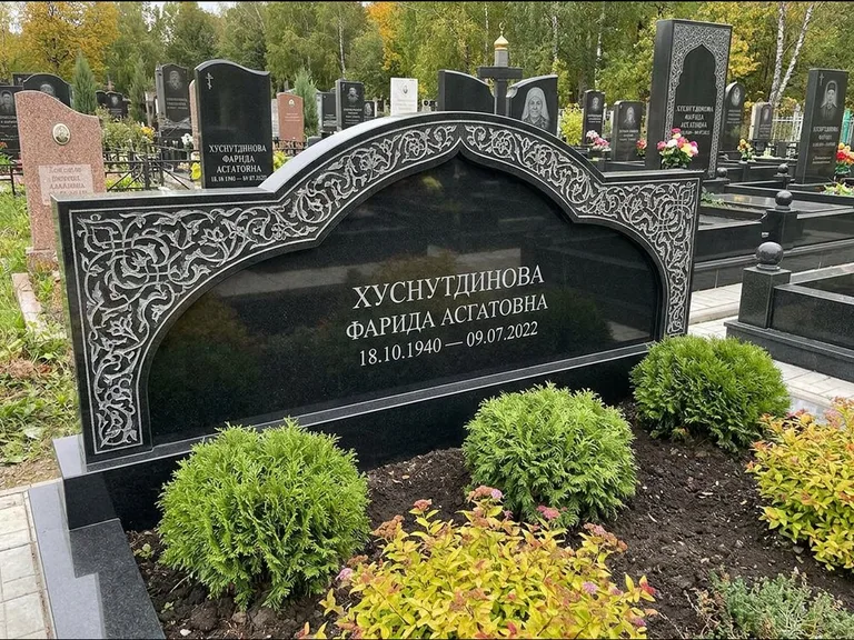 Мусульманский памятник: вытянутая горизонтальная семейная стела с аркой — белая гравировка силуэта мечети с минаретами, участок с декоративными кустами, работа «Зарипова» в Кемерово
