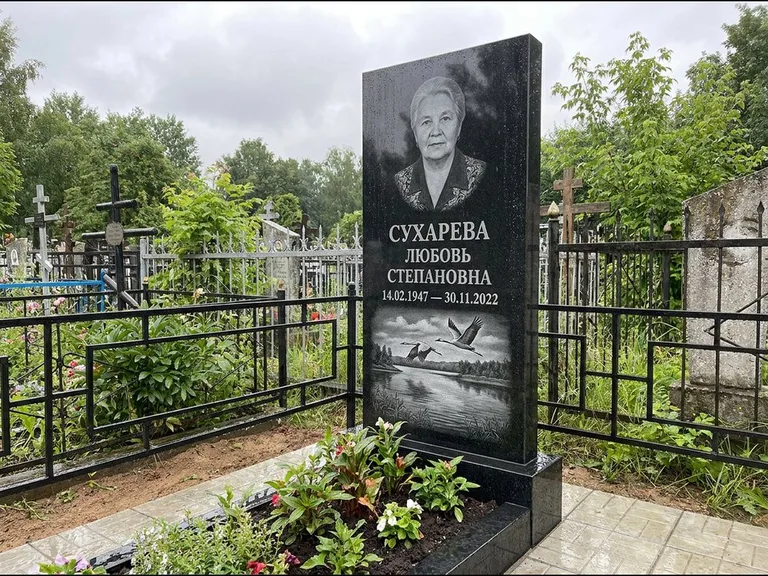 Памятник с гравировкой журавлей — гравировка пары журавлей над гладью озера в нижней части, работа «Сухарева» в Кемерово