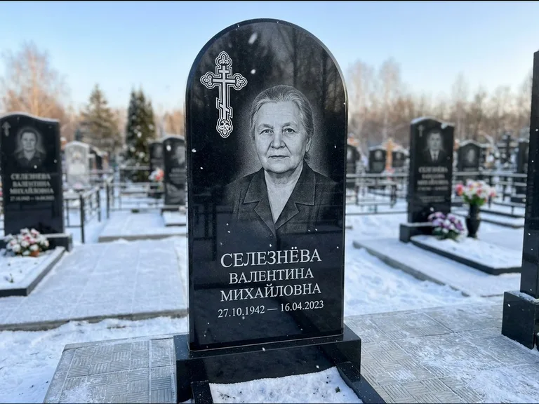 Памятник из чёрного гранита — массивная стела с крестом в лучах с крестом в лучах, работа «Одинцова» в Кемерово